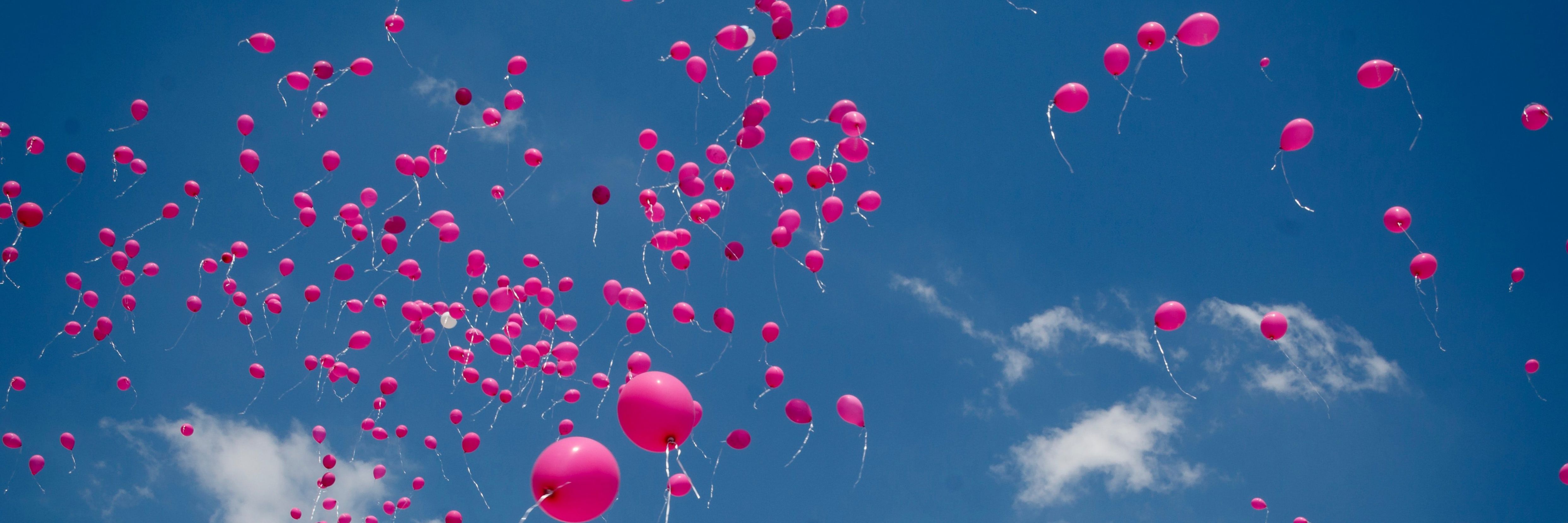 Mange lyserøde balloner stiger til vejrs