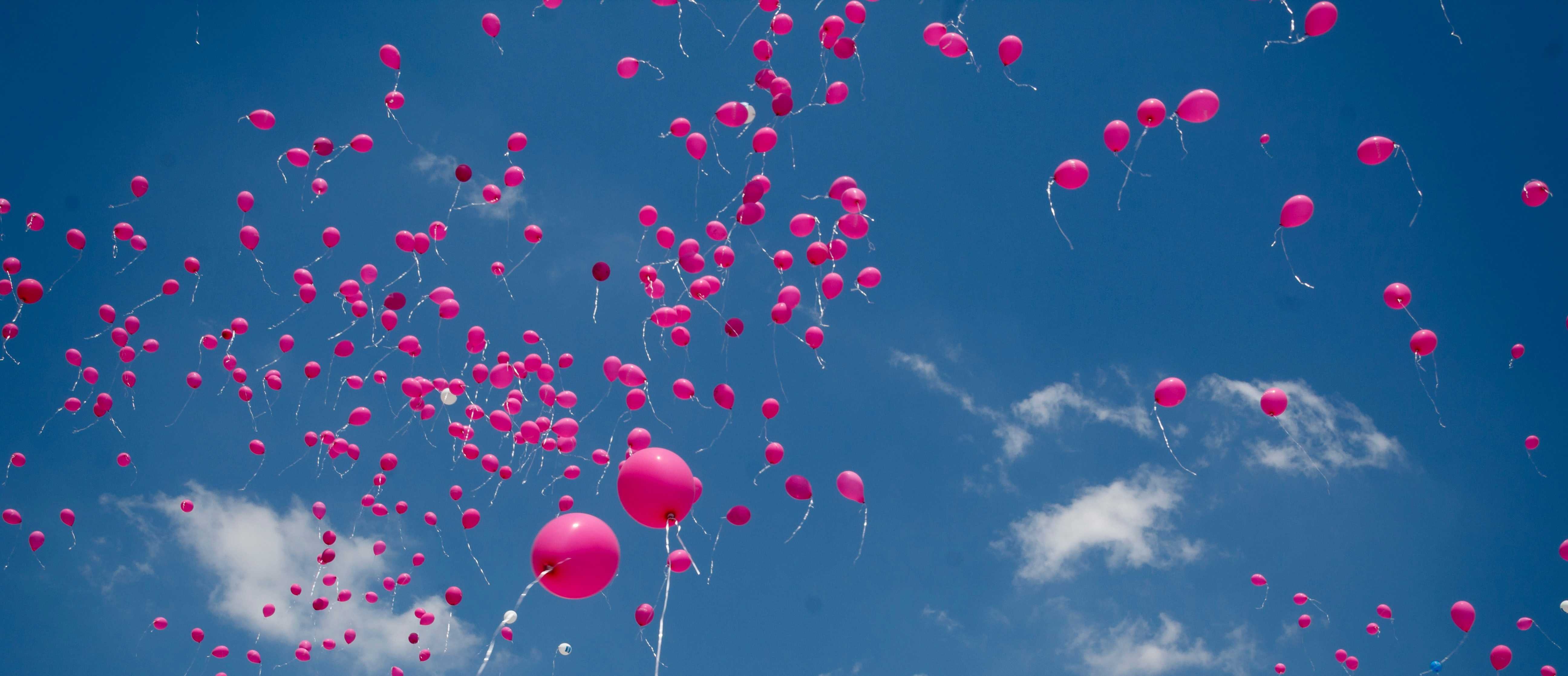 Mange lyserøde balloner stiger til vejrs