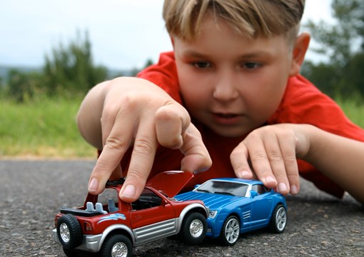 Dreng leger med legetøjsbiler